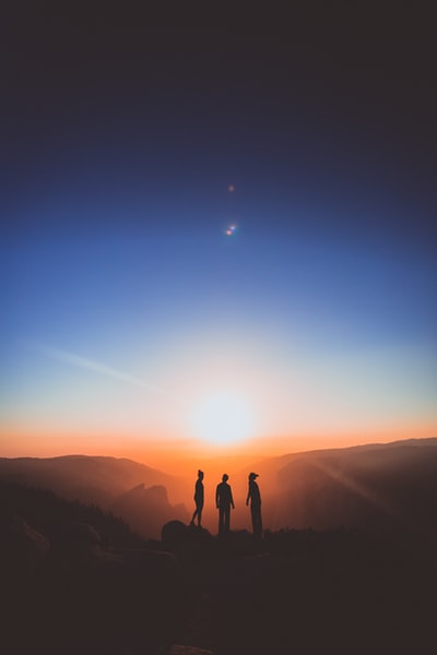三个人站在山的轮廓
